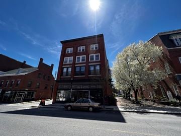 Biddeford apartment for rent - A car is parked on the side of a street in front of a building.