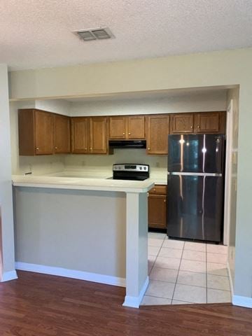Niceville house for rent - A kitchen with wooden cabinets and a stainless steel refrigerator.