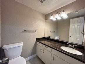 Bay City apartment for rent - A bathroom with a toilet, sink, and mirror.
