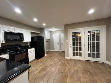 Bay City apartment for rent - A kitchen with black countertops and white cabinets.