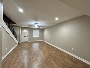 Bay City apartment for rent - A spacious room with wooden flooring and a staircase.