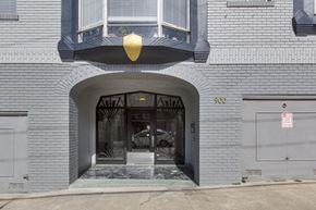 San Francisco apartment for rent - A grey building with a black awning and a sign that says 900.