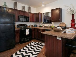 Lawrence apartment for rent - a large kitchen with black appliances and a rug