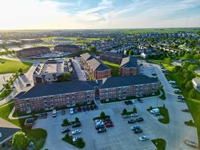 Ankeny apartment for rent - A large red brick building with a parking lot in front.