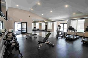 Ankeny apartment for rent - A gym with a variety of equipment including treadmills, weights, and exercise machines.