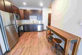 Ankeny apartment for rent - A kitchen with a refrigerator, microwave, oven, and sink.