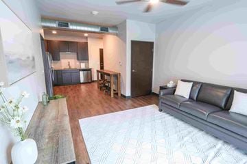 Ankeny apartment for rent - A modern living room with a grey couch and a wooden table.
