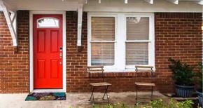 Fort Worth house for rent - A red door is on the left side of a white window.