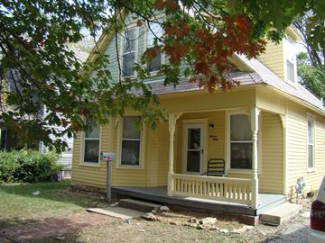 Lawrence apartment for rent - A yellow house with a mailbox on the front porch.