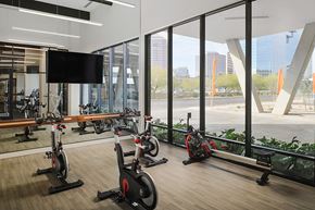 Phoenix apartment for rent - a gym with exercise bikes and a television
