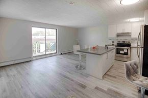 Niagara Falls apartment for rent - an empty living room with a kitchen and a large window