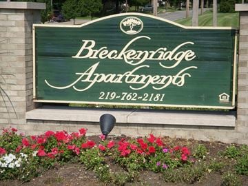 Portage apartment for rent - a sign at the front of a building with flowers