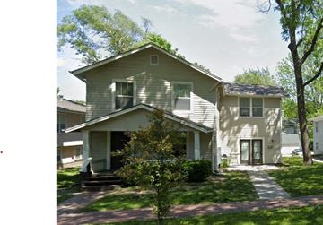 Lawrence apartment for rent - A two-story house with a front porch and a tree in front.