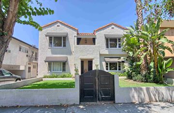 West Hollywood apartment for rent - a white house with a black gate in front of a yard