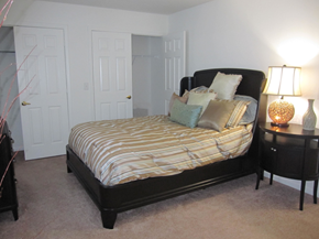 Easley apartment for rent - A bedroom with a bed, nightstand, and two doors.