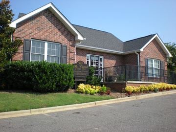 Shelby apartment for rent - the front of a brick house with a black wrought iron fence in front of it