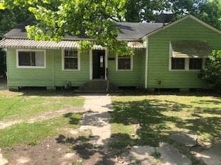 Baton Rouge house for rent - a green house with a tree in front of it