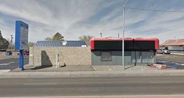 Albuquerque apartment for rent - A bus stop with a red awning is located on the side of a road.