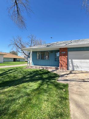 Fremont apartment for rent - A blue house with a red brick chimney and a closed grey garage door.