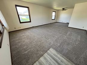 Fremont apartment for rent - A room with a grey carpet and a window overlooking a green area.