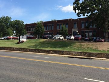 Hot Springs apartment for rent - A parking lot with cars and a building in the background.