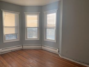 Irvington apartment for rent - three windows in a room with wooden floors and gray walls