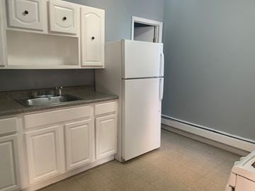 Irvington apartment for rent - a kitchen with white cabinets and a refrigerator