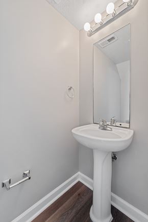 Jacksonville house for rent - A white pedestal sink in a small bathroom with a mirror above it.
