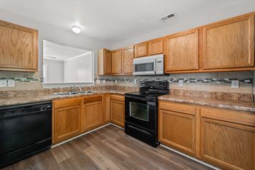 Jacksonville house for rent - A kitchen with wooden cabinets and black appliances.