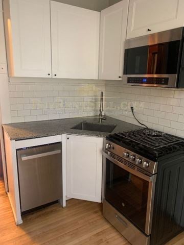 Minneapolis apartment for rent - A kitchen with white cabinets and a black stove top oven.