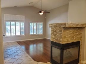 Chandler house for rent - A living room with a fireplace and a ceiling fan.