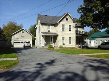 Black River apartment for rent - A large house with a garage is situated on a street.