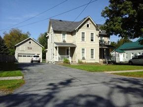 Black River apartment for rent - A large house with a garage is situated on a street.