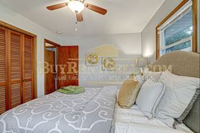 Crystal house for rent - A bedroom with a bed, pillows, and a ceiling fan.