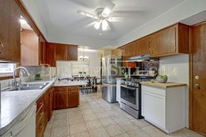 Crystal house for rent - A kitchen with wooden cabinets and a white oven.