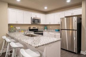 Sterling Heights apartment for rent - a kitchen with a granite counter top and a stainless steel refrigerator