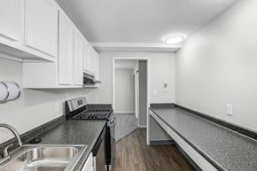 Columbus apartment for rent - A kitchen with white cabinets and a black stove top oven.