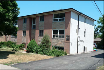Toronto apartment for rent - a brick building with a white wall and some bushes