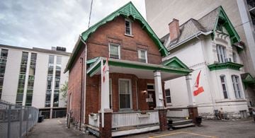 Ottawa apartment for rent - A red brick building with a green roof and white trim.