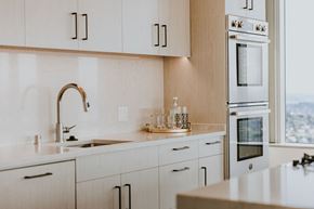 Seattle apartment for rent - a kitchen with white cabinets and a sink and a window