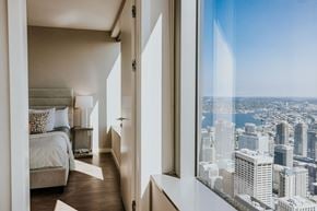 Seattle apartment for rent - a bedroom with a view of the city and a bed and a window