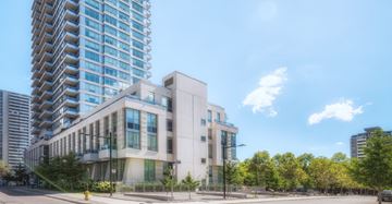 Toronto apartment for rent - A modern building with a glass facade stands tall in the city.