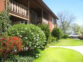 Geneva apartment for rent - a house with a sidewalk and flowering bushes