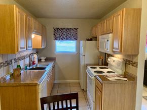 Killeen apartment for rent - a kitchen with white appliances and wooden cabinets