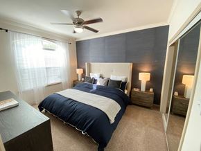 Houston apartment for rent - a bedroom with a bed and a ceiling fan
