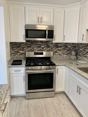 Maywood apartment for rent - A kitchen with a stove top oven and microwave above it.