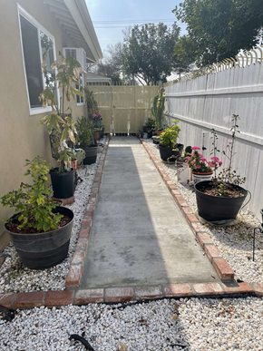 Maywood apartment for rent - A garden pathway with potted plants on either side.