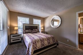 San Antonio apartment for rent - A bedroom with a bed, nightstands, and a mirror.