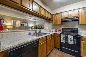 San Antonio apartment for rent - A kitchen with black appliances and wooden cabinets.