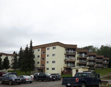 Chetwynd apartment for rent - a parking lot full of cars in front of an apartment building